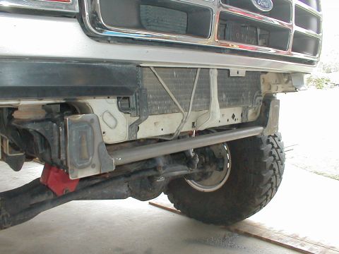 1996 Ford Bronco - Front view of a Ford truck's bumper and radiator, showing modifications and an off-road tire.