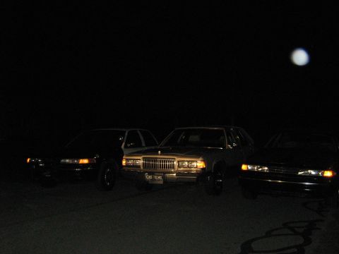 1988 Mercury Grand Marquis - A 1988 Mercury Grand Marquis is parked between two other sedans under the moonlight.