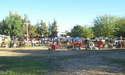1994 Ford F-150 - A busy outdoor market displays various tractors and stalls under a clear sky.