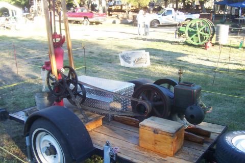 1994 Ford F-150 - An antique water pump and engine are displayed on a trailer at an outdoor event, with other vehicles visible in the background.