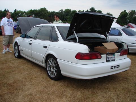 1993 Ford Taurus - A white 1993 Ford Taurus is displayed with its trunk open, revealing a cardboard box inside.