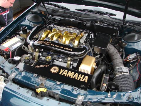 1993 Ford Taurus - Engine bay of a Ford SHO, a Yamaha-branded cover and gold intake runners.