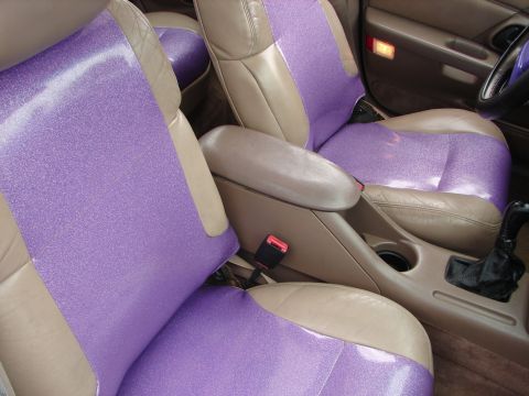 1993 Ford Taurus - Interior view of a 1993 Ford Taurus, showing tan leather seats with custom purple glitter covers.