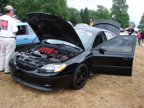 1993 Ford Taurus - Black sedan with hood and driver door open, showing custom red engine components.