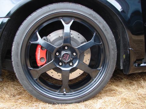 1993 Ford Taurus - Close-up of a black wheel a red 'COBRA' brake caliper and a center cap with 'SHO' branding.