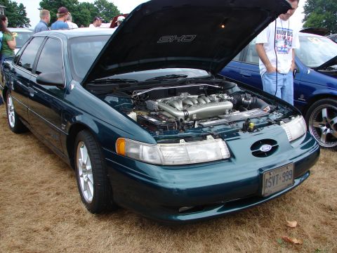 1993 Ford Taurus - A 1993 Ford Taurus SHO is displayed with its hood open, revealing the engine compartment.