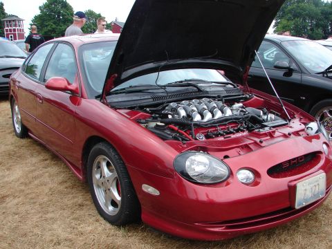 1993 Ford Taurus - Red 1996 Ford Taurus SHO with its hood open, revealing the V8 engine. Another car is visible to the right.