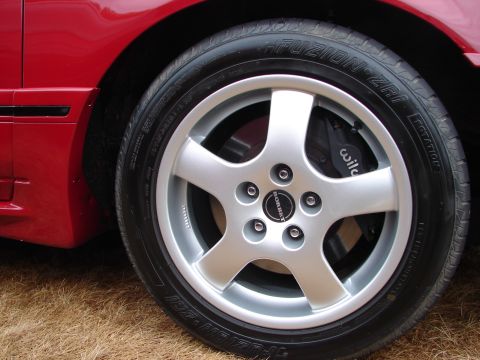 1993 Ford Taurus - A close-up view of a red vehicle's wheel, aftermarket Borbet rims and Wilwood brake calipers.