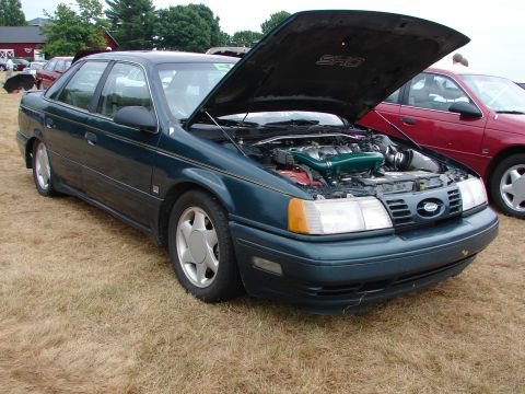 1993 Ford Taurus - The engine bay of a 1993 Ford Taurus SHO is displayed with the hood open.