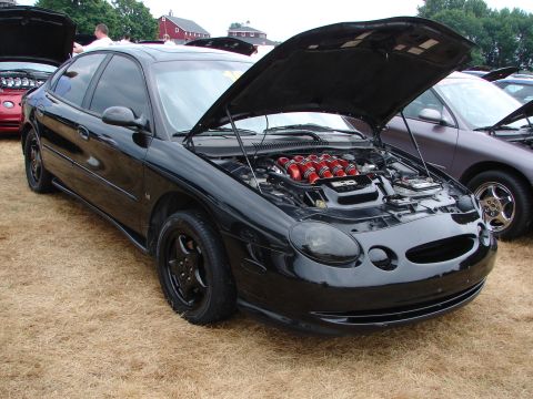 1993 Ford Taurus - A black 1993 Ford Taurus SHO is displayed with its hood open, its engine and intake system at a car show.
