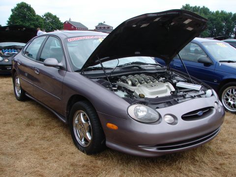 1993 Ford Taurus - This Ford Taurus has its hood open, displaying the V8 engine. A second vehicle is visible to the right.