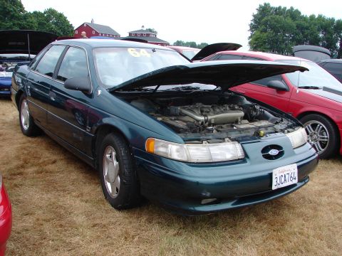 1993 Ford Taurus - A green sedan is parked outside with its hood open, revealing the engine compartment.
