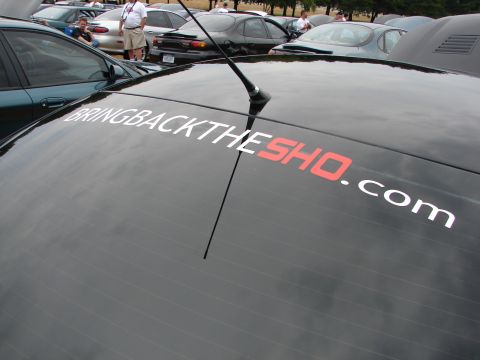 1993 Ford Taurus - Sticker on a car's rear window reads 'BRINGBACKTHESHO.COM'.