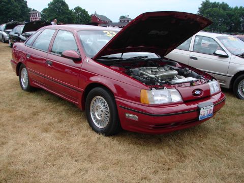 1993 Ford Taurus - Red 1993 Ford Taurus sedan at a car show, hood open to display the engine.