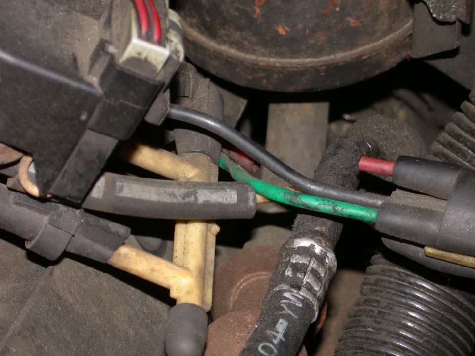 Close-up of engine bay showing vacuum lines, connectors, and wiring