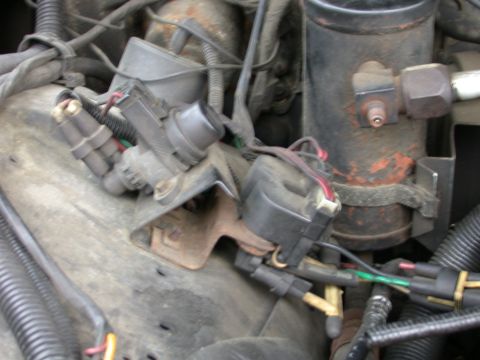 1987 Lincoln Town Car - Close-up view of engine bay components, including vacuum hoses and electrical connectors, likely related to vacuum leaks.