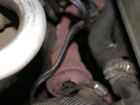 1987 Lincoln Town Car - Close-up of exhaust manifold and hoses, likely from an older vehicle.