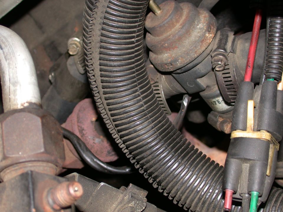 Close-up of engine vacuum hoses and a rusty valve