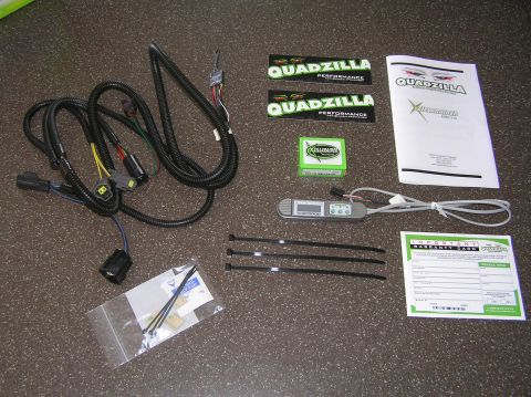2000 Ford Excursion - This image displays a collection of automotive performance parts, including a wiring harness, stickers, and a digital tuning module.