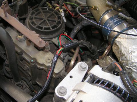 2000 Ford Excursion - Close-up view of engine components, including wiring, hoses, and a labeled pipe.