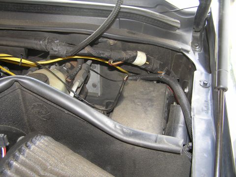 2000 Ford Excursion - Close-up view of the engine bay wiring and components, including a fuse box and reservoir.