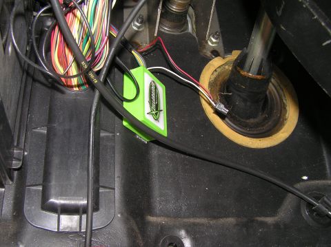 2000 Ford Excursion - A close-up view of an aftermarket electronic module and its wiring harness installed in a vehicle's interior.