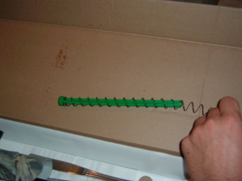 1986 Ford Bronco - A gun magazine spring is shown with its green follower inside a cardboard box.
