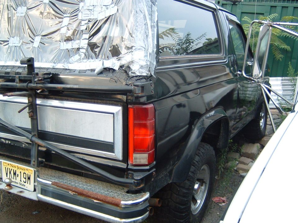 Rear of a dark green Ford Bronco with a silver tailgate panel and a New Jersey license plate