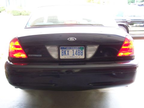 2003 Ford Crown Victoria - Rear view of a dark blue 2003 Ford Crown Victoria Police Interceptor with its brake lights illuminated.