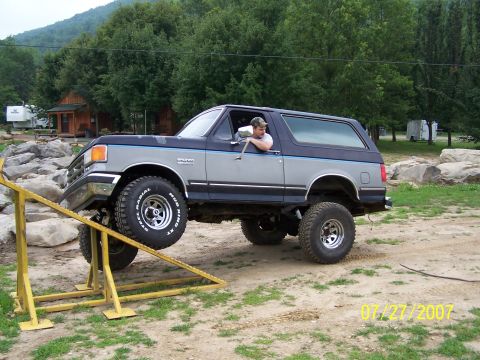 1979 Ford F-150 - A lifted Ford Bronco navigates an obstacle course on a dirt track.