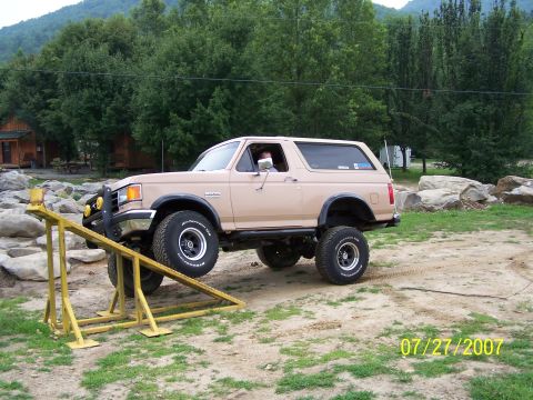 1979 Ford F-150 - Tan Ford Bronco with off-road tires is positioned on a yellow ramp.