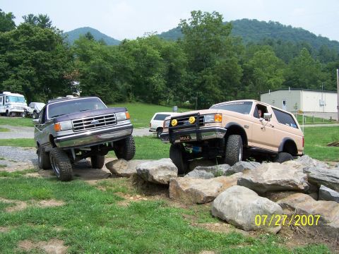 1979 Ford F-150 - Two lifted Ford trucks, a Bronco and an F-Series, navigate a rocky obstacle course.