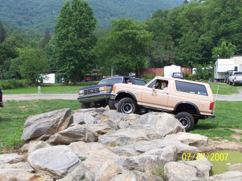 1979 Ford F-150 - Two Ford trucks, a Bronco and a pickup, tackle a challenging rock crawling course on a summer day.