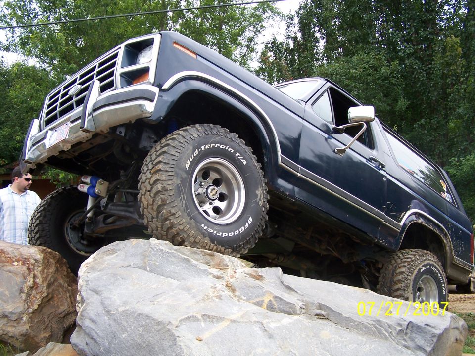 Dark blue SUV with large tires on rocks, 1978 model year