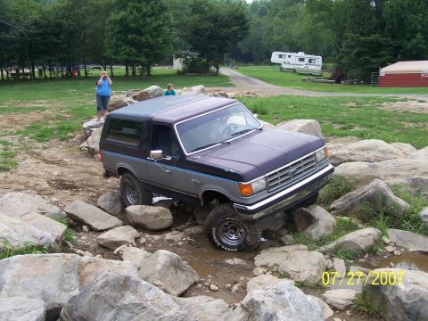 1979 Ford F-150 - A Ford Bronco is shown off-roading over a rocky terrain.