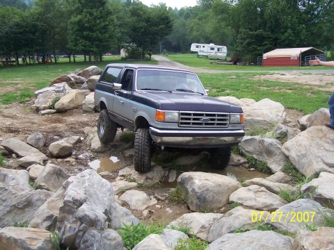 1979 Ford F-150 - A Ford Bronco is shown off-roading over a rocky terrain.