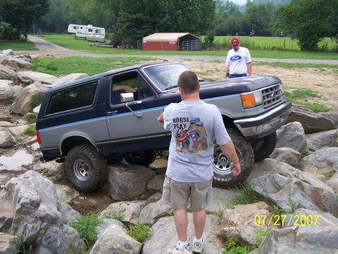1979 Ford F-150 - A Ford Bronco is shown attempting to drive over large rocks on an off-road course.