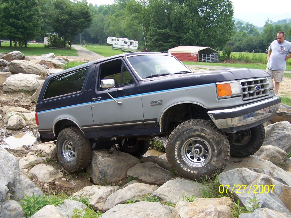Gray and blue Ford Bronco navigating rocks