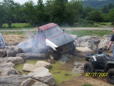 1979 Ford F-150 - A modified pickup truck navigates a challenging off-road obstacle course with an ATV in attendance.