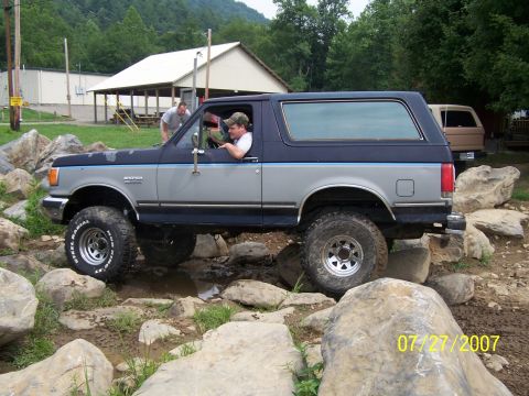 1979 Ford F-150 - A modified Ford Bronco drives over rocks on an off-road course.
