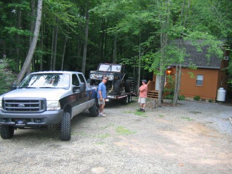 1992 Ford Mustang - Ford F-250 Super Duty and a classic Ford Bronco on a trailer at a wooded cabin site.