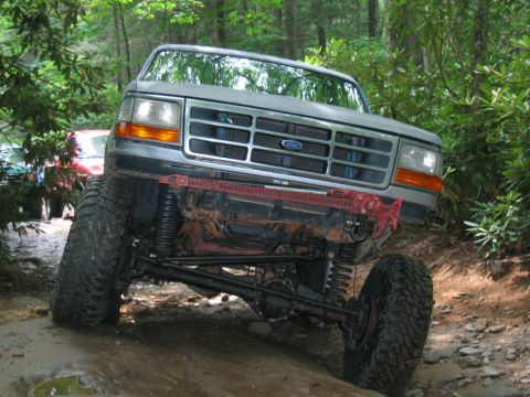 1992 Ford Mustang - This modified Ford truck navigates a rocky trail, its off-road capabilities and distinctive grille.