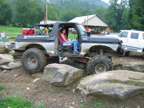 1992 Ford Mustang - Modified Ford Bronco tackling an off-road obstacle course with large tires.