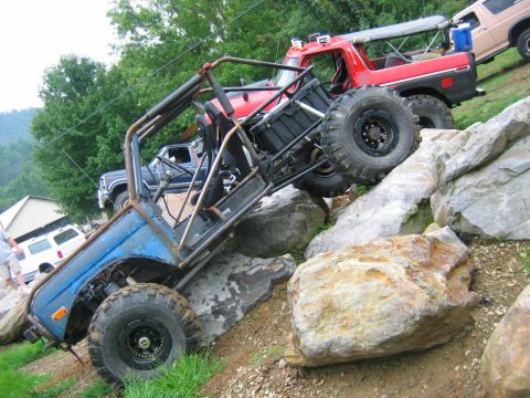 1992 Ford Mustang - Custom off-road buggy navigates a rocky incline, with other trucks visible in the background.