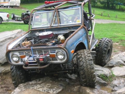 1992 Ford Mustang - This heavily modified off-road buggy navigates a rocky terrain, a prominent roll cage and a front-mounted winch.