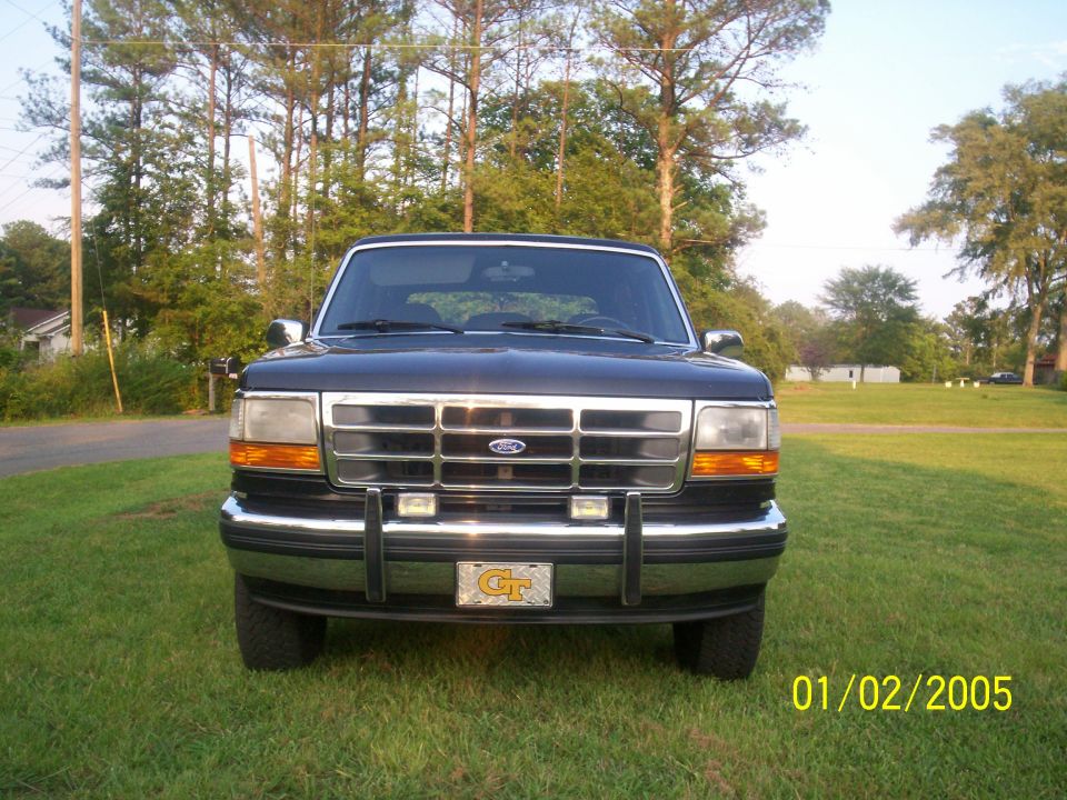 Front view of a dark blue Ford Bronco parked on grass. Has a Georgia Tech license plate