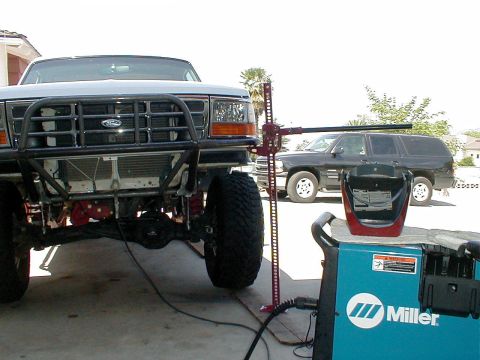 1996 Ford Bronco - A modified Ford Bronco is shown from the front, with a high-lift jack attached to its bumper.