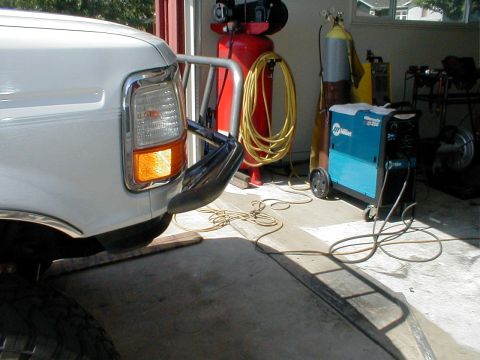 1996 Ford Bronco - Front corner of a 1996 Ford Bronco parked next to welding equipment in a garage.