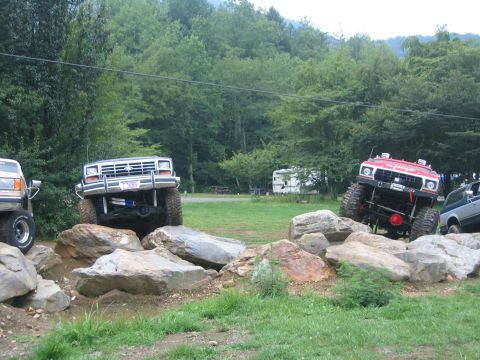 1979 Ford Bronco - Modified trucks tackle a challenging rock obstacle course during an off-road event.