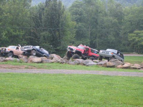 1979 Ford Bronco - Multiple off-road vehicles, including a red 1978 Ford Bronco, traverse a rocky obstacle course.